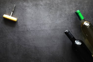 Masada bir bardak kırmızı şarap. Siyah şişe ve bir bardak şarap..