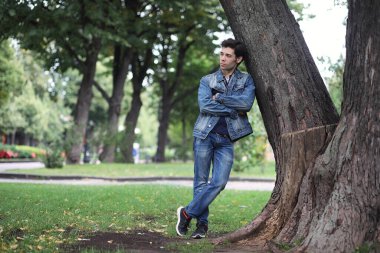 Genç bir adam öğle yemeği zamanında parkta yürür. Bir adam şehirde gezintiye çıktı. Park eden bir öğrenci.