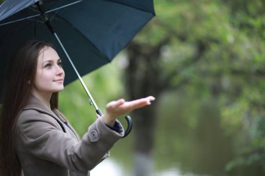 Rai 'deki bir bahar parkında ceketli genç bir kız.