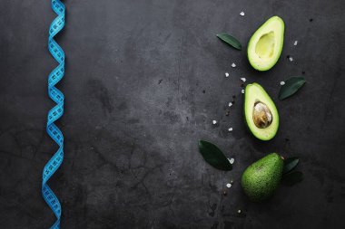 Avokado yemek tarifleri. Tahta kesme tahtasında servis edilen olgun yeşil avokado..