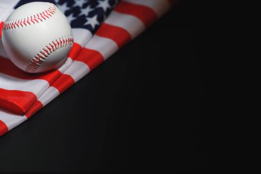 Amerikan geleneksel spor oyunu. Beyzbol mu? Kavram. Amerikan bayrağıyla birlikte beyzbol topu ve sopalar masada..
