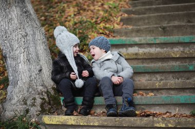 Çocuklar sonbahar parkında sonbaharda yürürler
