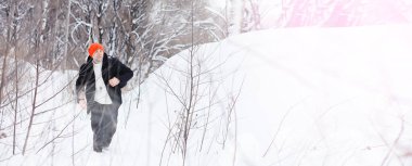 Kışın ormanda bir adam. Sırt çantalı bir turist kışın ormana gider..