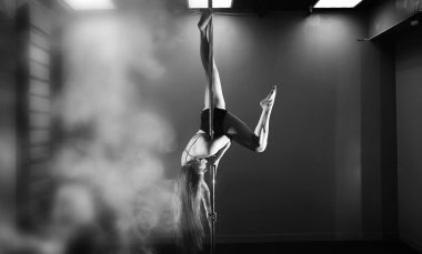 Spor aletleri üzerinde egzersiz yapan bir kız. Stüdyodaki direğin üstündeki dansçı..