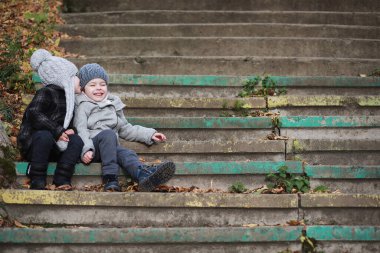 Çocuklar sonbahar parkında sonbaharda yürürler