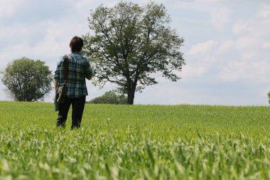 Genç bir adam kaybolmamak için doğadaki haritaya bakar.