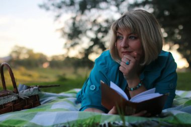 kadınla çimenlerin üzerinde kitapla Park