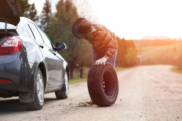 男は自然の中で車で道路に座っている — ストック写真