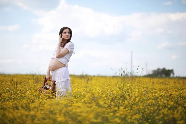 孕妇穿着花地里的连衣裙 — 图库照片