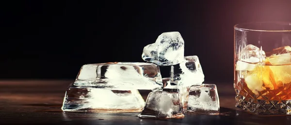 木製のカウンターで氷と強いアルコール飲料のガラス 氷のキューブとウィスキー 冷たい飲み物とガラス — ストック写真