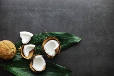 Hindistan cevizi koyu taş bir masada. Hindistan cevizi yağı ve cips.