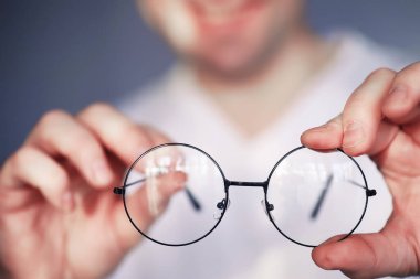 Kötü görüş kavramı. Kontak lens ve gözlüğü elinizde tutun. Reklam gözlükleri ve lensler için poster.