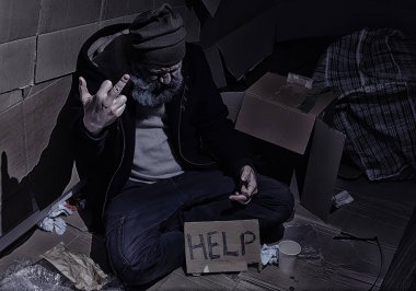 Evsiz sakallı bir adam sokakta kutulara oturup yardım istiyor. Evsiz bir insan yemek için para ister ve bir gecede.