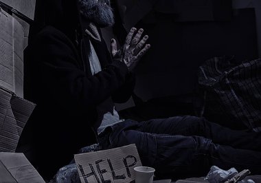 Evsiz sakallı bir adam sokakta kutulara oturup yardım istiyor. Evsiz bir insan yemek için para ister ve bir gecede.