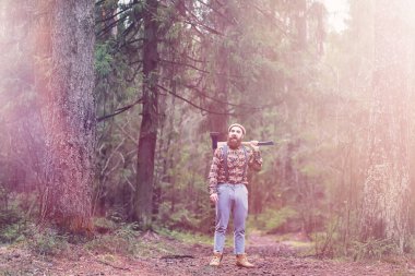 Büyük bir balta ile sakallı bir oduncu ağaç felling önce inceler