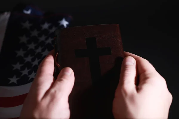 美国国旗和圣经上关于镜子背景的书 美国和宗教的象征 圣经和黑底条纹旗 — 图库照片