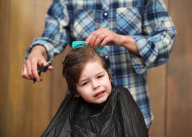 Küçük bir çocuk kuaförün parlak duygularıyla süslenir.