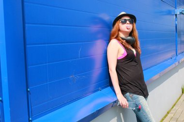 Hafif şapkalı ve güneş gözlüklü bir kız.