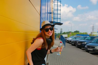 Hafif şapkalı ve güneş gözlüklü bir kız.