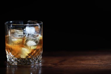 Tahta tezgahta buzlu sert bir alkollü içecek. Buzlu viski alayım. Bardakla soğuk bir içecek..