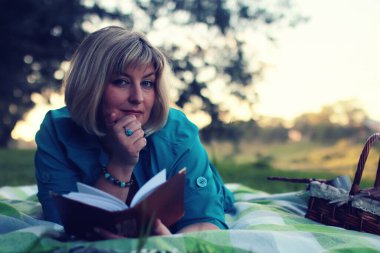 kadın yatıyordu ve kitap Güneş okuyun