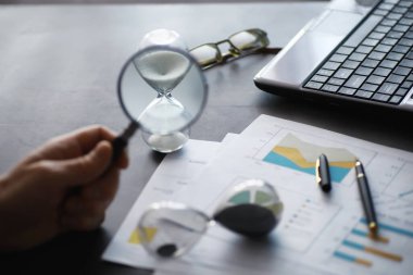 Çalışma zamanı kum saatini sembolize eder. Sigorta müdürü ve bankacı ile ofis masası. Ofis çalışanı masada. Zaman eksikliği kavramı.