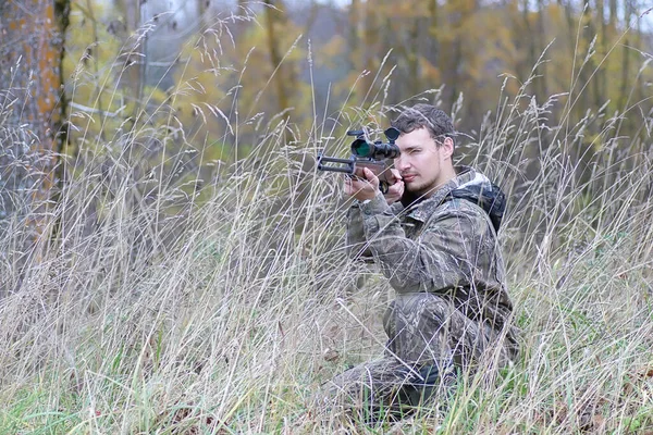 迷彩服の男と春の狩りの森のベルトの銃を持つ男 — ストック写真