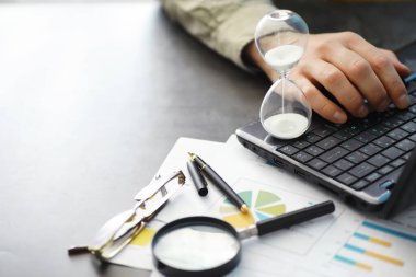 Çalışma zamanı kum saatini sembolize eder. Sigorta müdürü ve bankacı ile ofis masası. Ofis çalışanı masada. Zaman eksikliği kavramı.