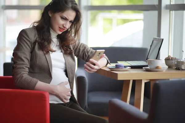 妊娠中の女性は カフェでコンピュータ上で昼食中に働く — ストック写真