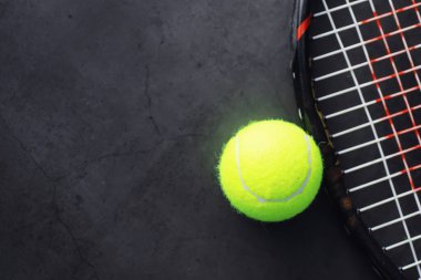 Spor ve sağlıklı yaşam tarzı. Tenis mi? Tenis için sarı top ve masada raket. Tenis konsepti olan spor geçmişi.