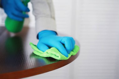 Ev temizliği konsepti. Yüzeylerin tozunu sil. Dezenfektan kapısı TV elektriğini kontrol ediyor. Evdeki karantinada hijyenik tedavi.