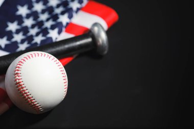 Amerikan geleneksel spor oyunu. Beyzbol mu? Kavram. Amerikan bayrağıyla birlikte beyzbol topu ve sopalar masada..