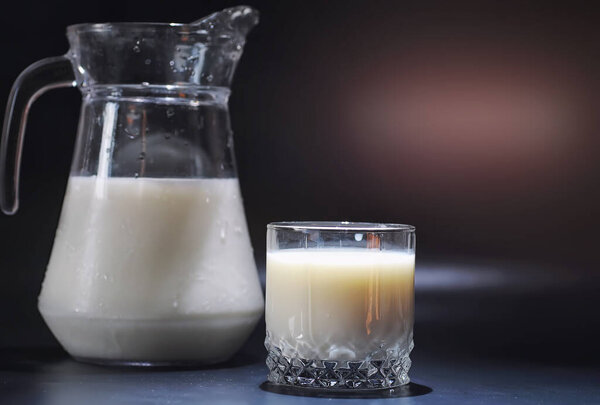 Молочный напиток в стакане. Фермерское молоко и печенье. Вкусная закуска с коровьим молоком и свежей выпечкой.