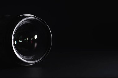 Operatör masasındaki kameraya görüntü. Fotoğraf merceğinin camında bir işaret fişeği. Siyah arkaplan ve fotoğrafçı tekniği..