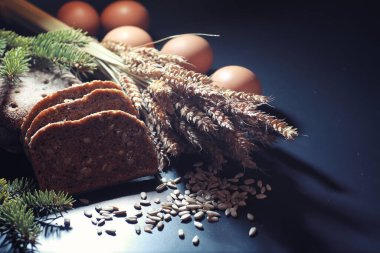 Siyah bir masada buğday ve glüten ile taze somun ekmek. Fırın ve market konsepti. Taze, sağlıklı çavdar ve beyaz somun ekmeği, çuval bezi üzerine serpiştirilmiş un. Tahıllı taze ev yapımı ekmek..