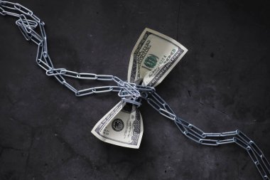 İş konsepti. Ulusal para biriminin değer kaybı. Yüz dolarlık banknot. Enflasyon ve durgunluk. 100 dolarlık banknotu bir ölçü zinciri ile sıkılaştır..