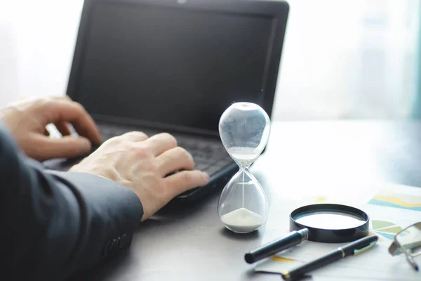 Working time symbolizes an hourglass. Office desk with insurance manager and banker. Office employee at the table. The concept of lack of time.