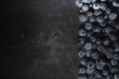 Olgun tatlı yaban mersinine su damlası. Metnin için fotokopi alanı olan taze yabanmersini arkaplanı. Vejetaryen ve vejetaryen kavramı. Yaban mersinli böğürtlenlerin makro dokusu. Yaban mersinli dokular kapanıyor.