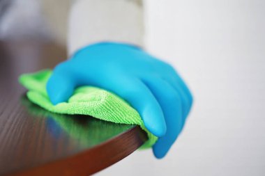 Ev temizliği konsepti. Yüzeylerin tozunu sil. Dezenfektan kapısı TV elektriğini kontrol ediyor. Evdeki karantinada hijyenik tedavi.