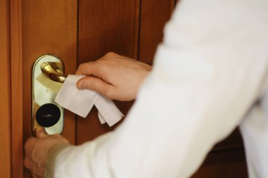 Ev temizliği konsepti. Yüzeylerin tozunu sil. Dezenfektan kapısı TV elektriğini kontrol ediyor. Evdeki karantinada hijyenik tedavi.