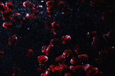 Olgun tatlı nar tohumlarına su damlaları düşer. Metnin için kopyalama alanı olan taze nar arkaplanı. Vejetaryen ve vejetaryen kavramı.