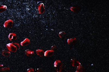 Olgun tatlı nar tohumlarına su damlaları düşer. Metnin için kopyalama alanı olan taze nar arkaplanı. Vejetaryen ve vejetaryen kavramı.