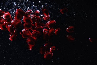 Olgun tatlı nar tohumlarına su damlaları düşer. Metnin için kopyalama alanı olan taze nar arkaplanı. Vejetaryen ve vejetaryen kavramı.