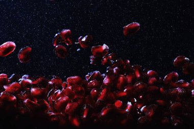 Olgun tatlı nar tohumlarına su damlaları düşer. Metnin için kopyalama alanı olan taze nar arkaplanı. Vejetaryen ve vejetaryen kavramı.