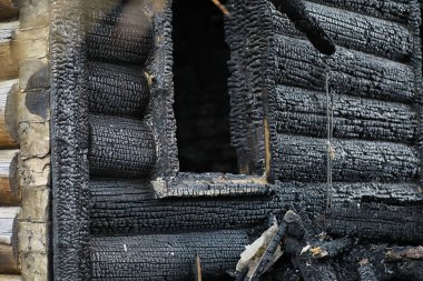 Yangından sonra ahşap ev. Kütüklerdeki kömürleri. Evin külleri yangından. Yanmış kır evi..