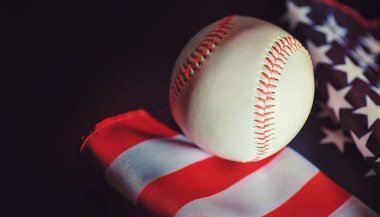 Amerikan geleneksel spor oyunu. Beyzbol mu? Kavram. Amerikan bayrağıyla birlikte beyzbol topu ve sopalar masada..
