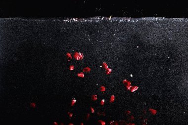 Olgun tatlı nar tohumlarına su damlaları düşer. Metnin için kopyalama alanı olan taze nar arkaplanı. Vejetaryen ve vejetaryen kavramı.