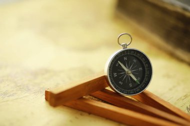 Seyahat ve macera arama konsepti. Eski bir harita, eski bir kitap ve pusula. Masada eski püskü bir kitap ve pusula var..
