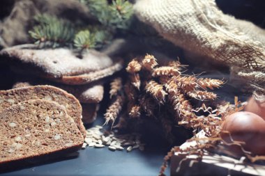 Siyah bir masada buğday ve glüten ile taze somun ekmek. Fırın ve market konsepti. Taze, sağlıklı çavdar ve beyaz somun ekmeği, çuval bezi üzerine serpiştirilmiş un. Tahıllı taze ev yapımı ekmek..