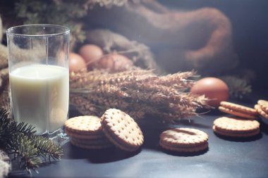 Siyah bir masada buğday ve glüten ile taze çıtır kurabiye. Fırın ve market konsepti. Taze, sağlıklı çavdar ve beyaz kurabiyeler, çuval bezine sütle serpiştirilmiş un. Mısır gevrekli ev yapımı kurabiye..